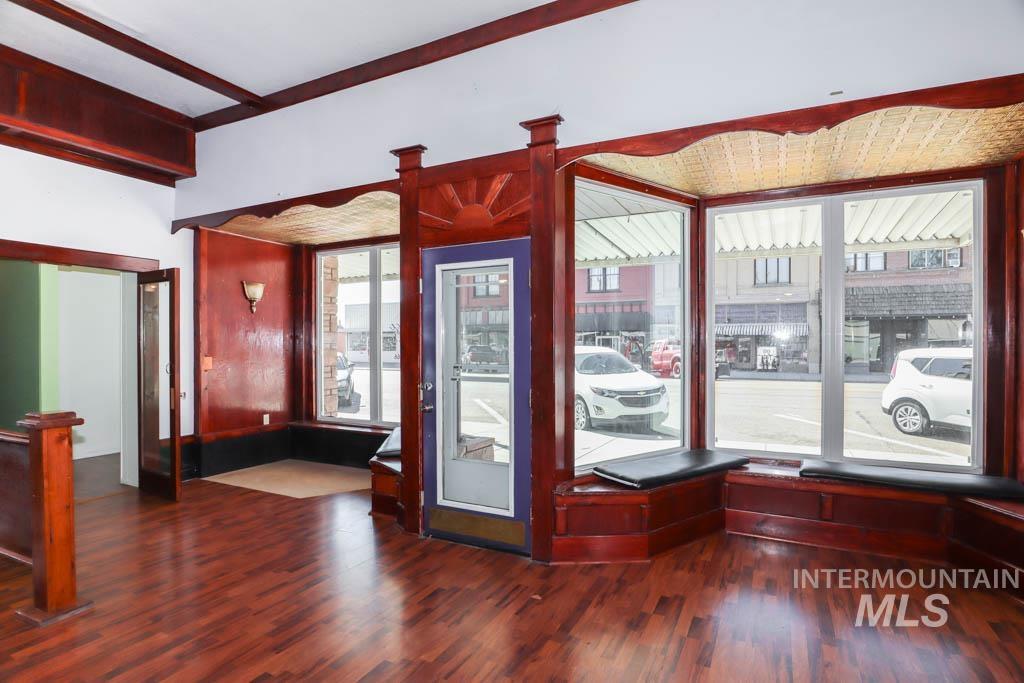 Entrance foyer featuring dark wood-style flooring and beam ceiling