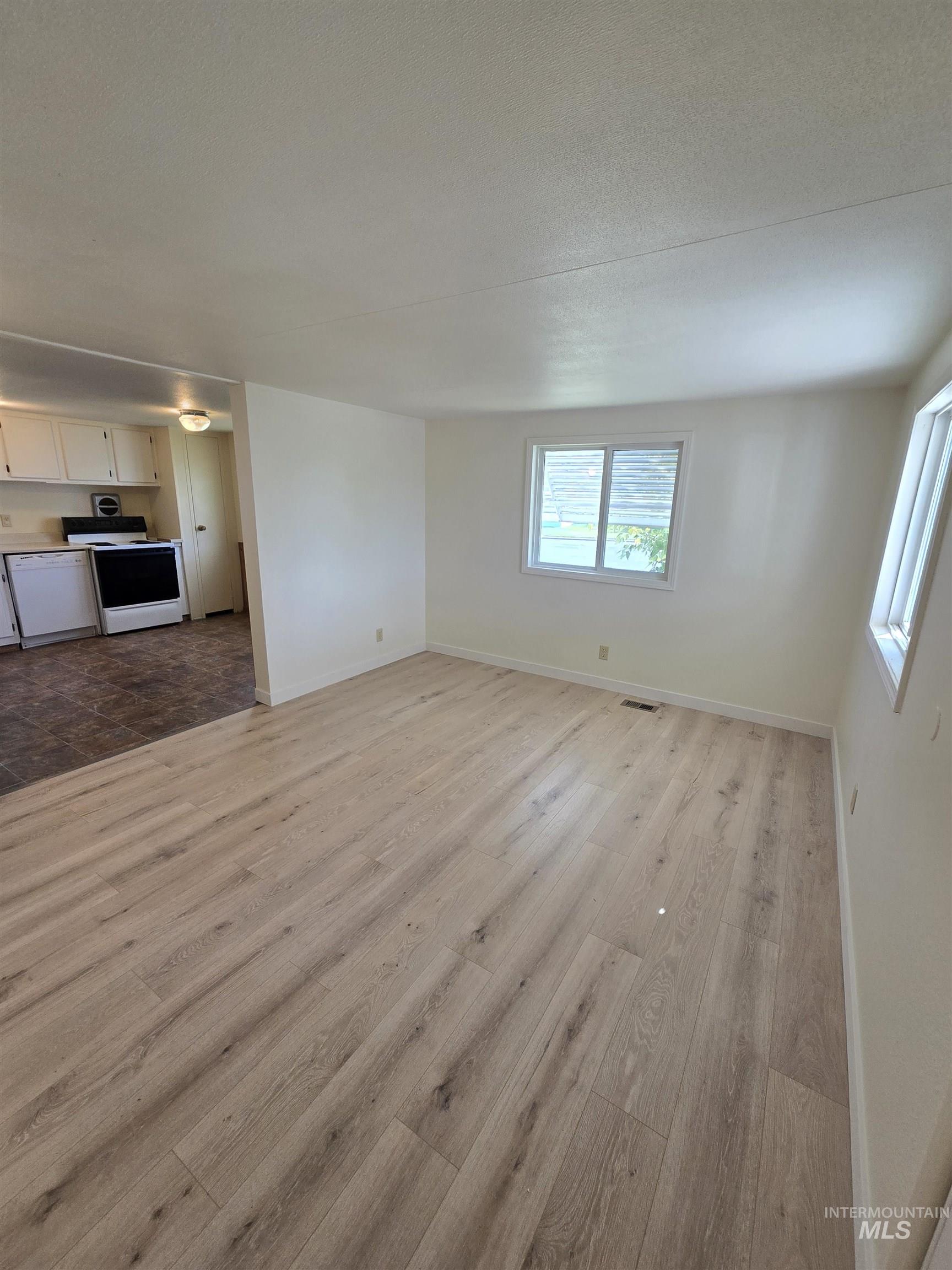 Unfurnished living room featuring wood finished floors and a textured ceiling