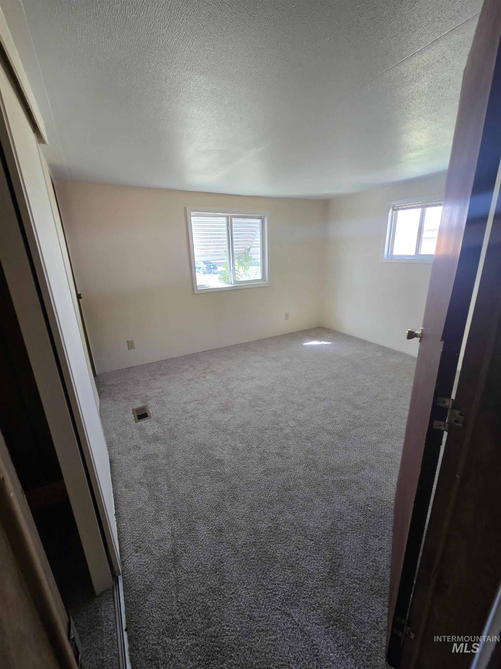 Unfurnished room with carpet flooring and a textured ceiling