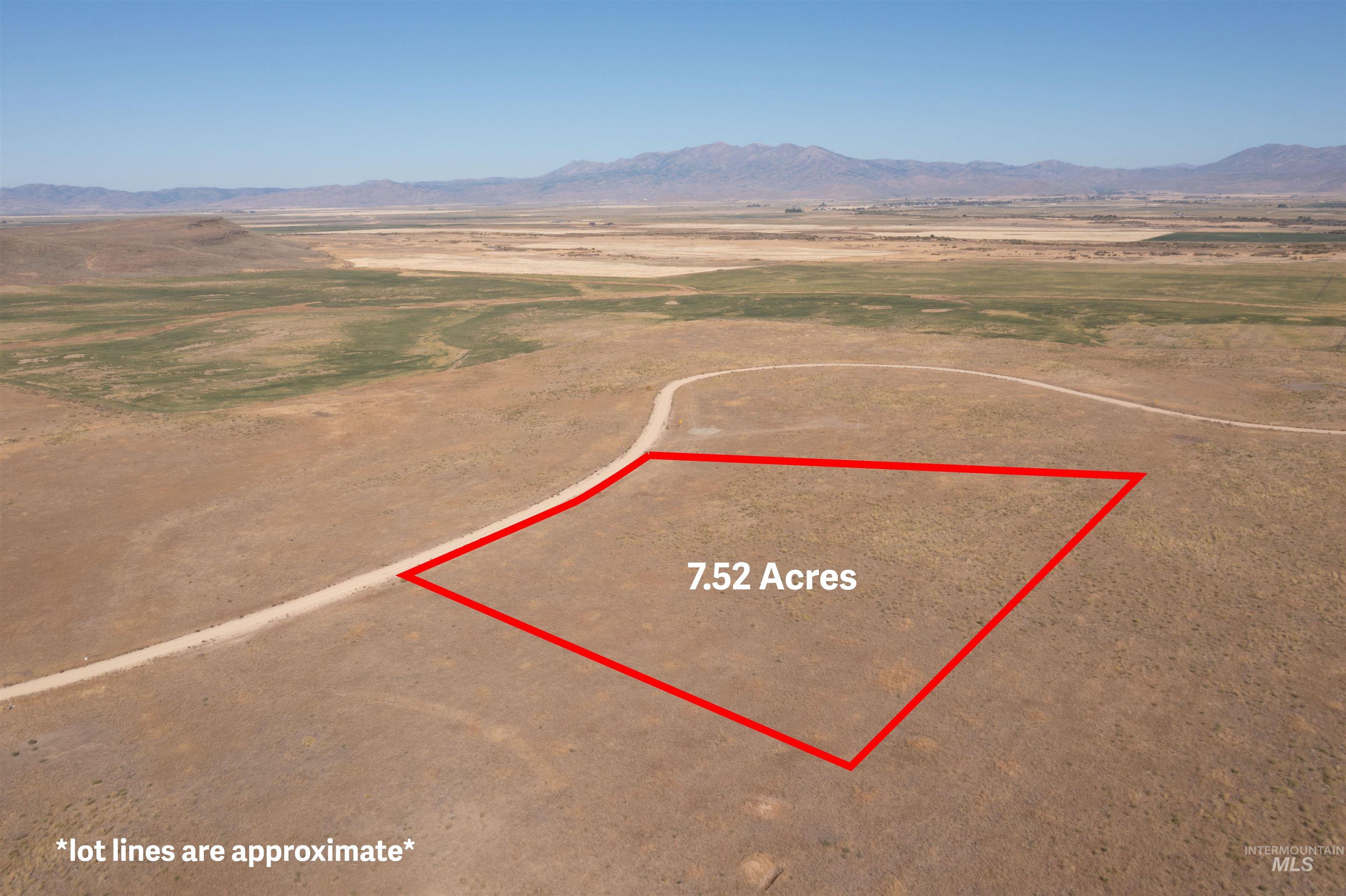Aerial view of sparsely populated area featuring property parcel outlined and a mountain backdrop