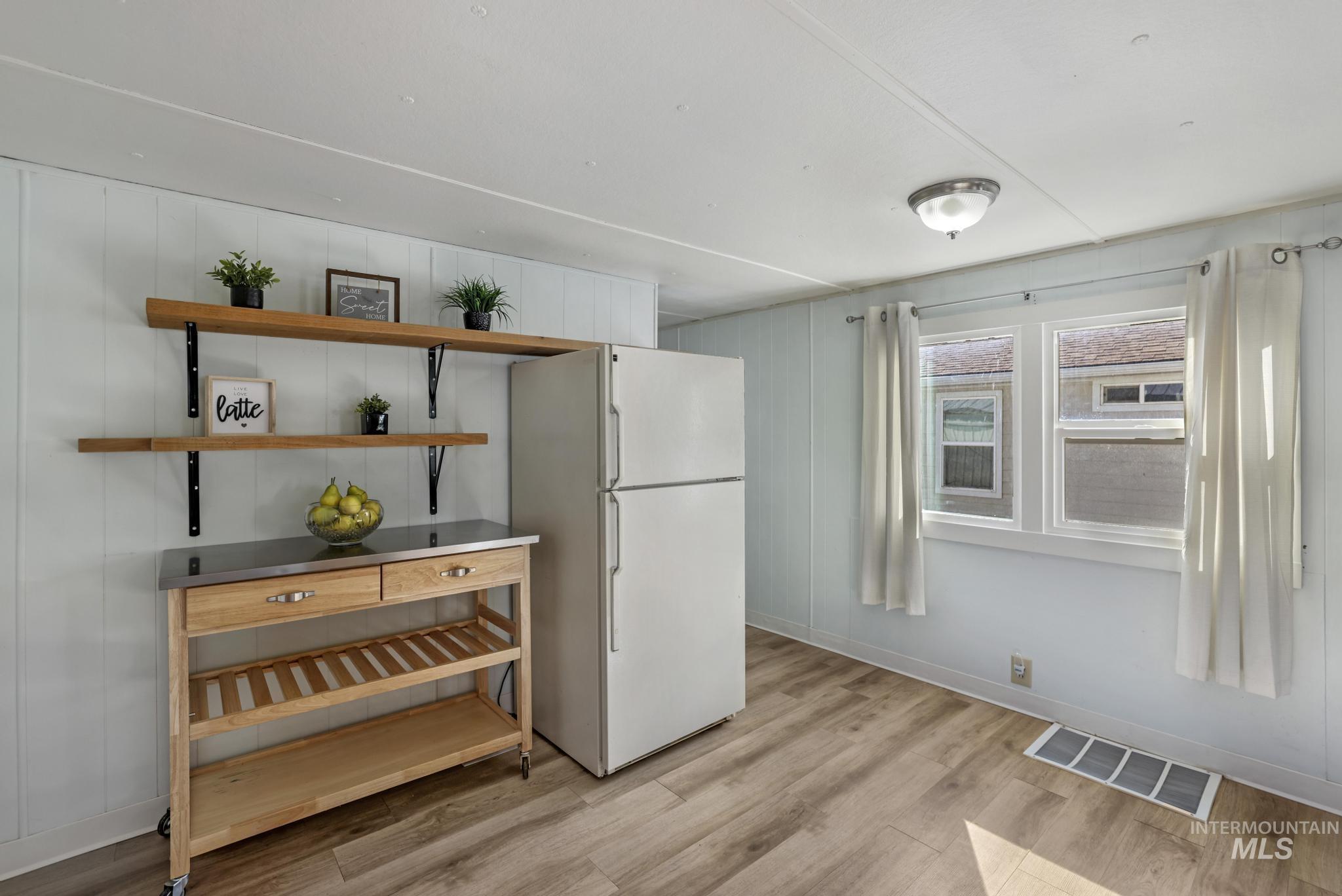 Dining area featuring light wood-style flooring and wooden walls
