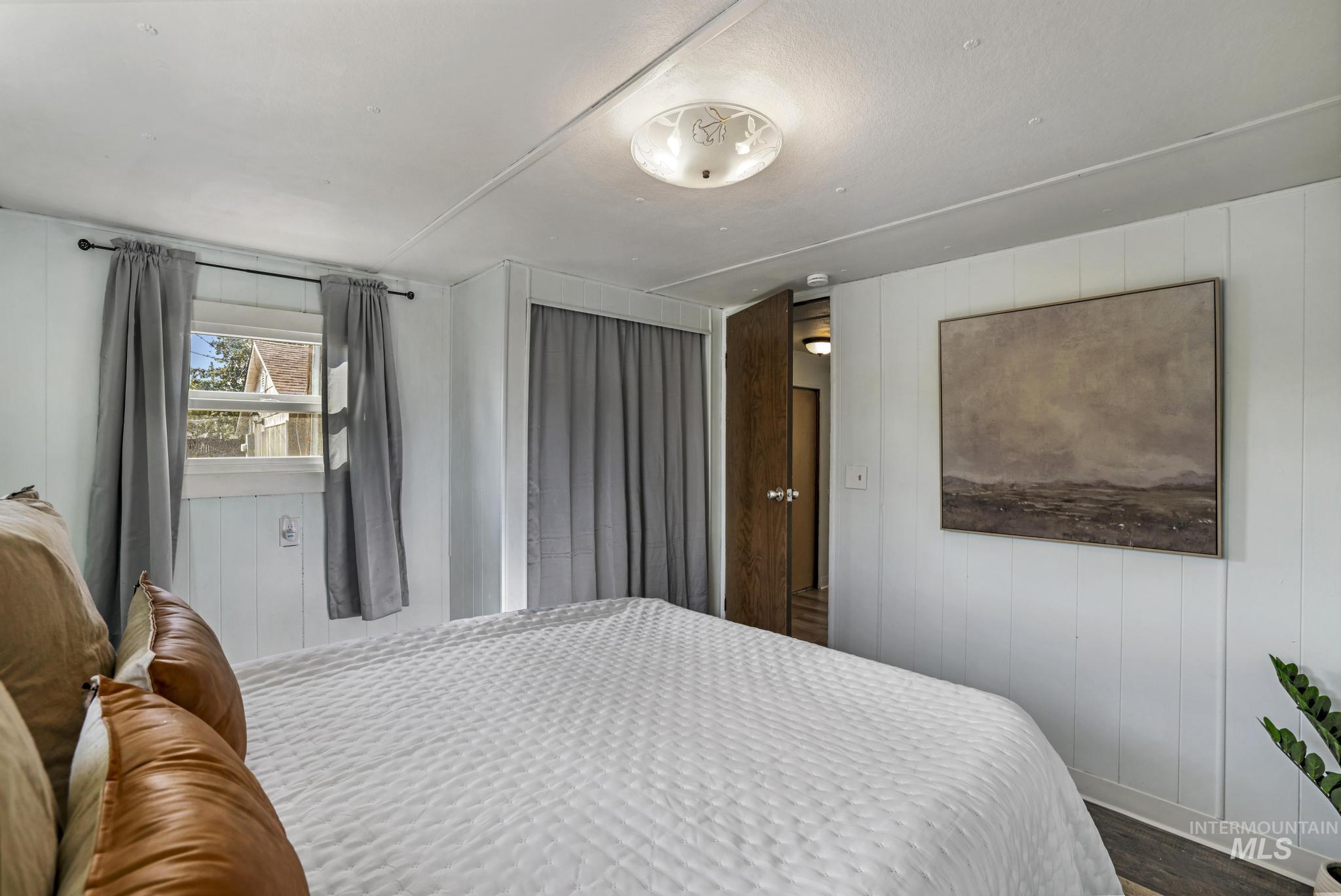 Bedroom with wood walls and wood finished floors