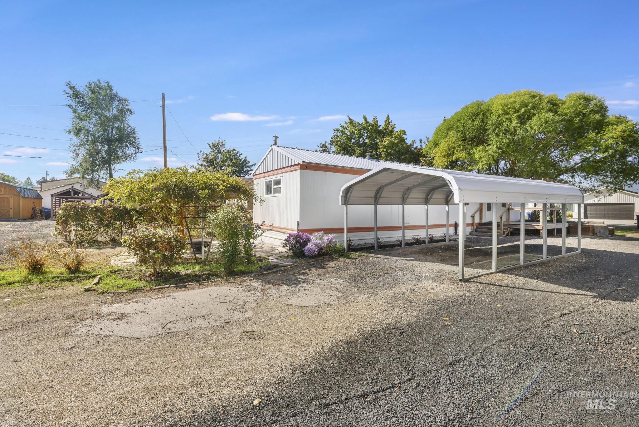 View of car parking with a carport and gravel driveway