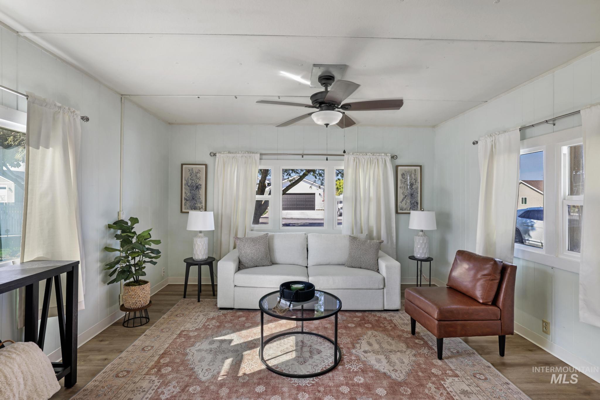 Living area featuring healthy amount of natural light, wood finished floors, and ceiling fan