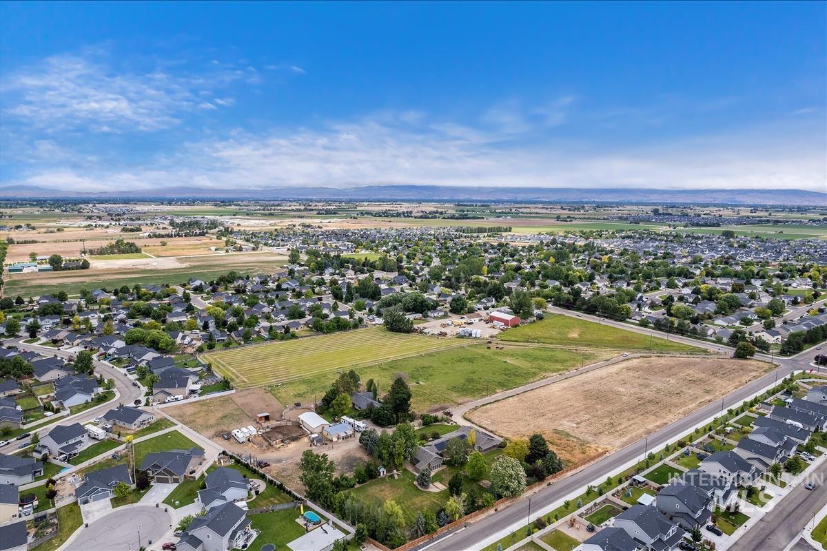 Aerial view of property and surrounding area with nearby suburban area