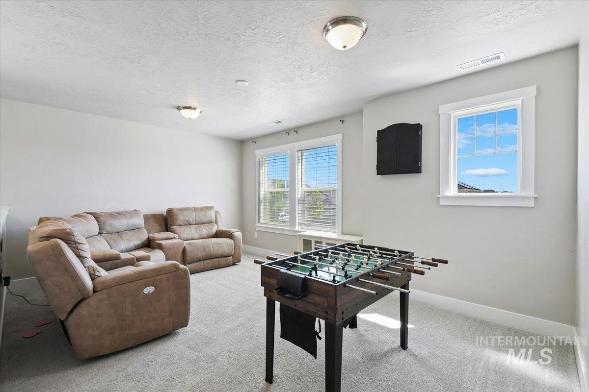 Playroom with light colored carpet and a textured ceiling
