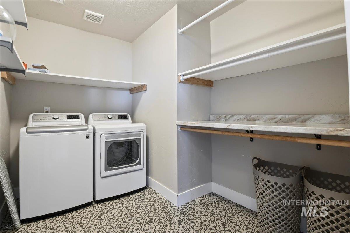 Washroom featuring washing machine and dryer and baseboards