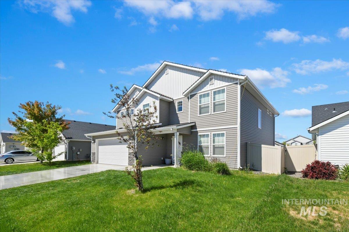 View of front of property featuring board and batten siding, a garage, and concrete driveway