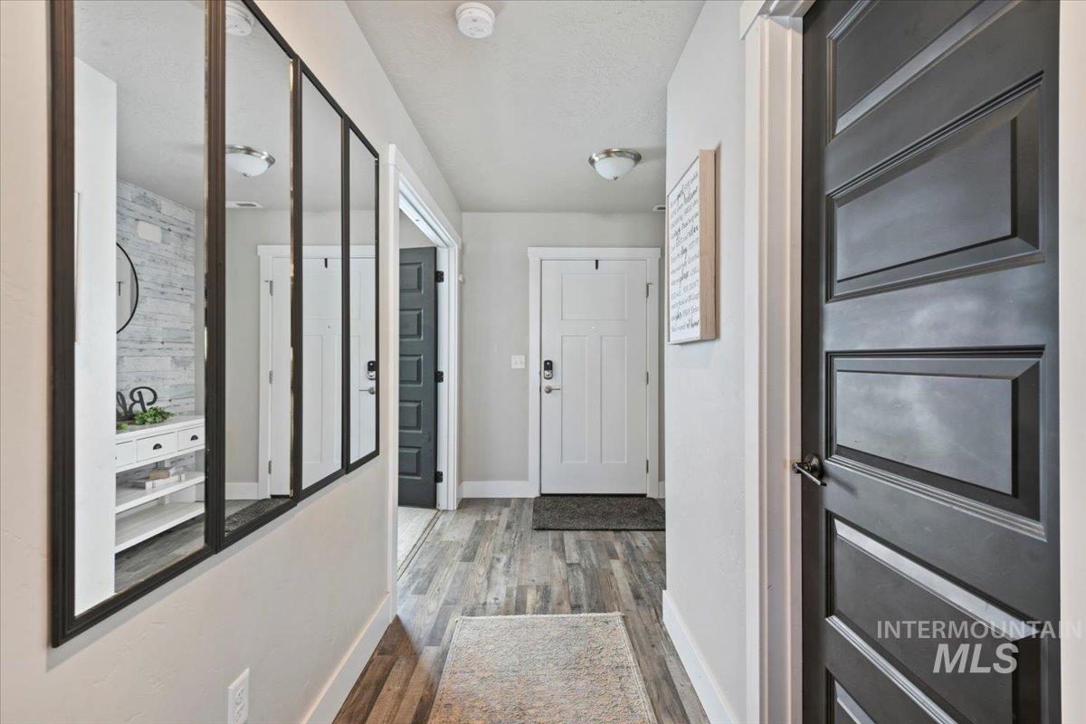 Hallway with wood finished floors and a textured ceiling