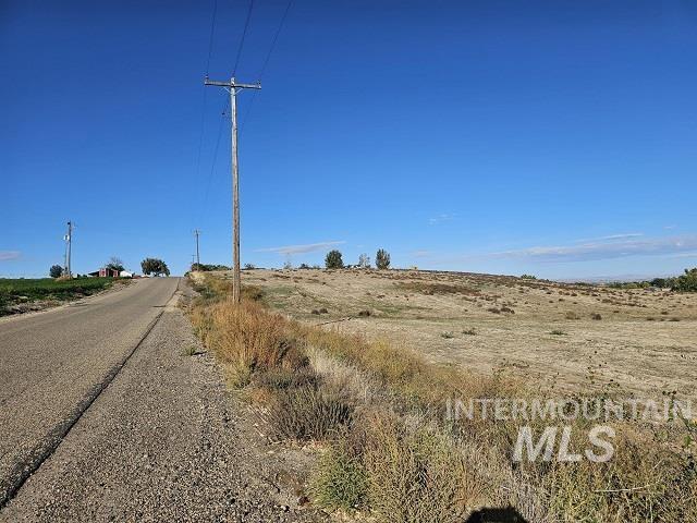 View of asphalt road featuring a view of rural / pastoral area