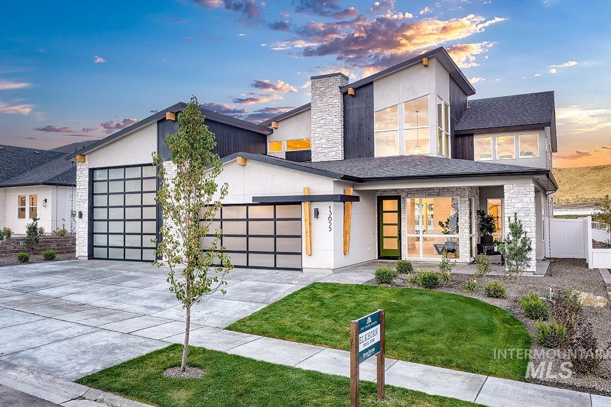 Modern home with a garage, driveway, stucco siding, stone siding, and french doors