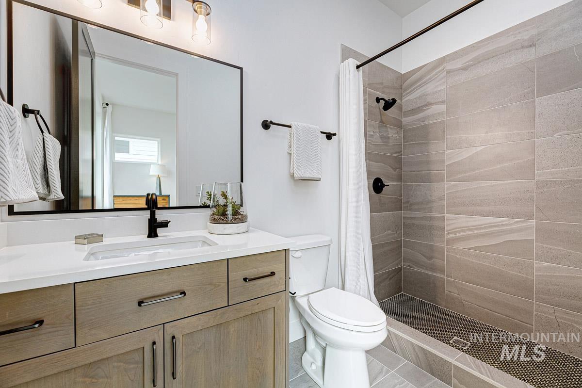 Full bath featuring vanity, a shower stall, and tile patterned flooring