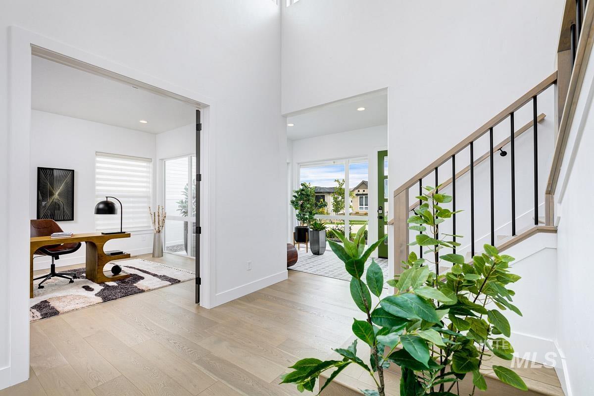 Foyer with light wood-style floors, stairs, recessed lighting, and a high ceiling