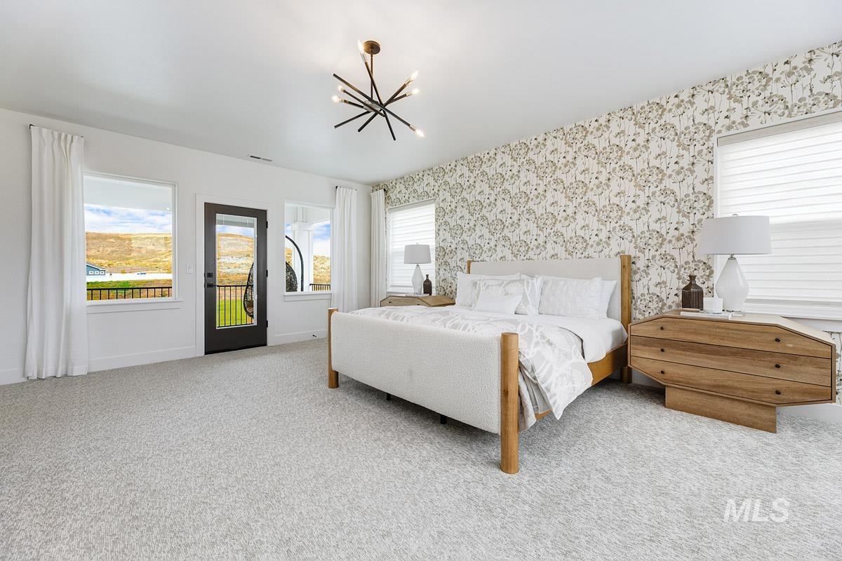 Bedroom with multiple windows, access to outside, light carpet, a chandelier, and wallpapered walls