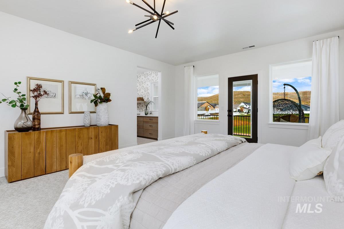 Bedroom with carpet floors, access to outside, and a chandelier