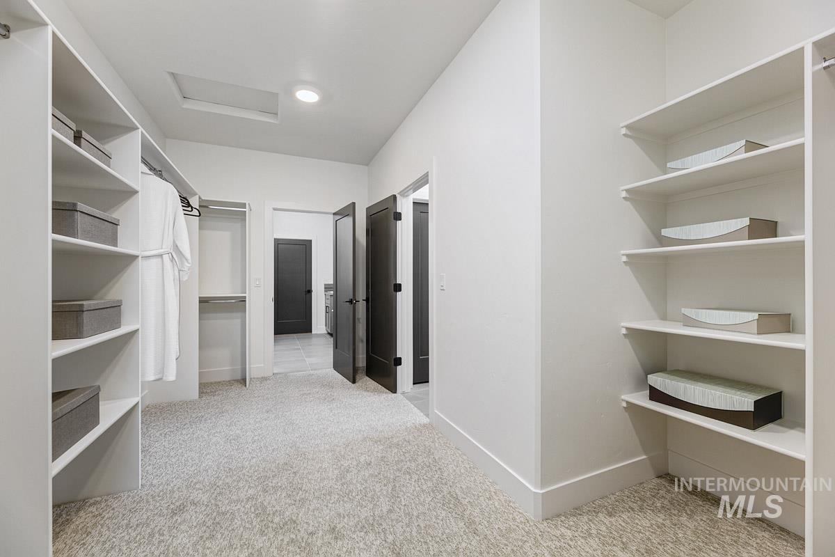 Spacious closet with light carpet and attic access