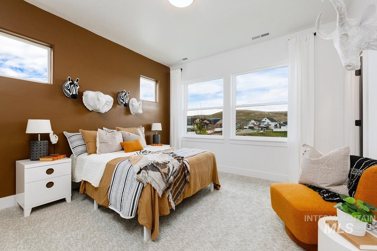 Bedroom with multiple windows and light carpet