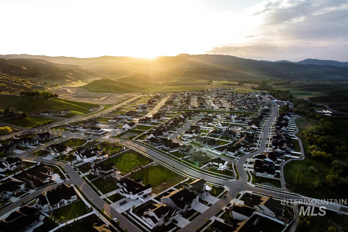 Aerial overview of property's location with nearby suburban area and a mountainous background