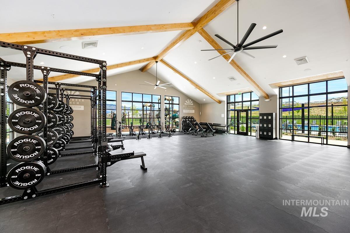 Workout area with beam ceiling, high vaulted ceiling, and recessed lighting