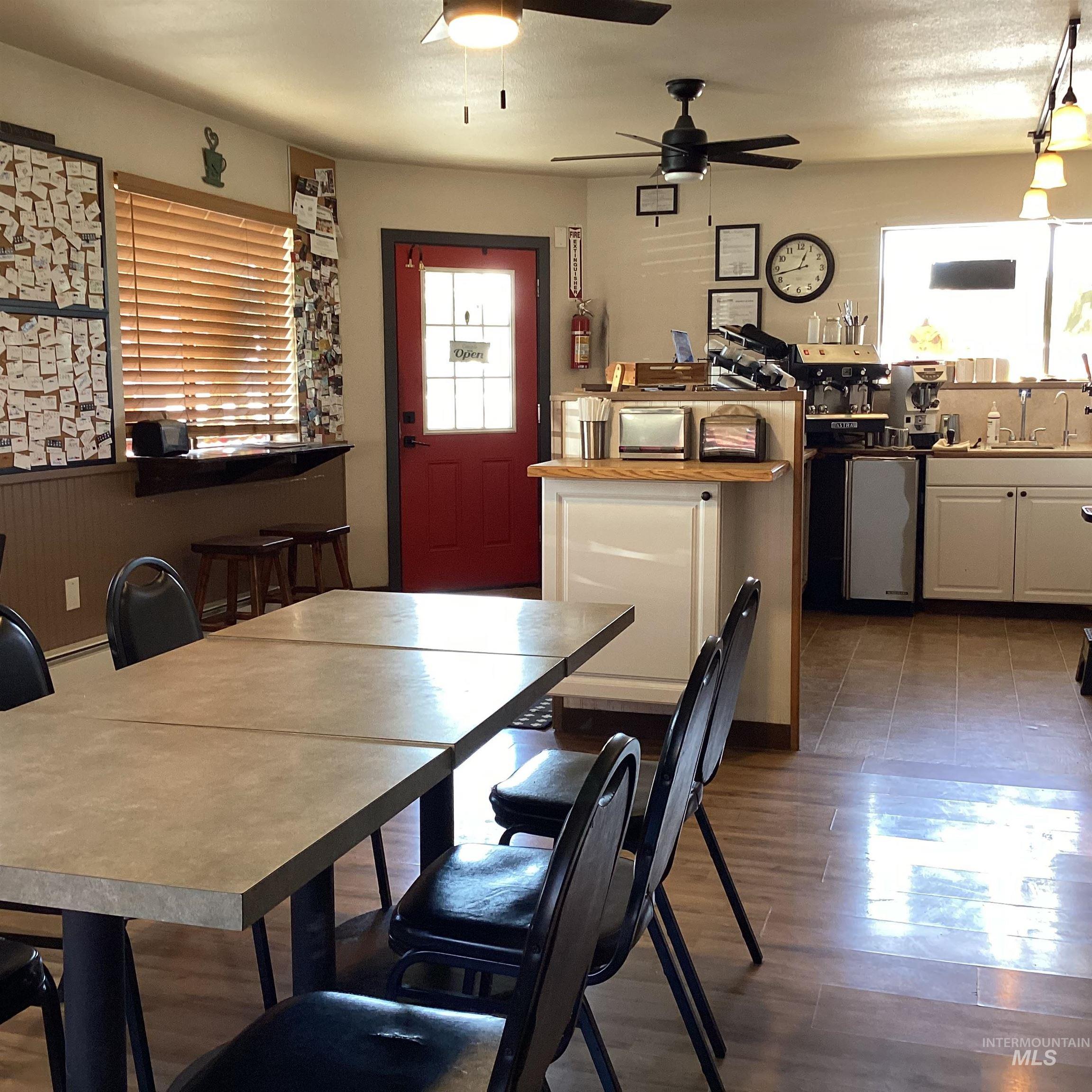 Dining room featuring dark wood-style floors and a ceiling fan