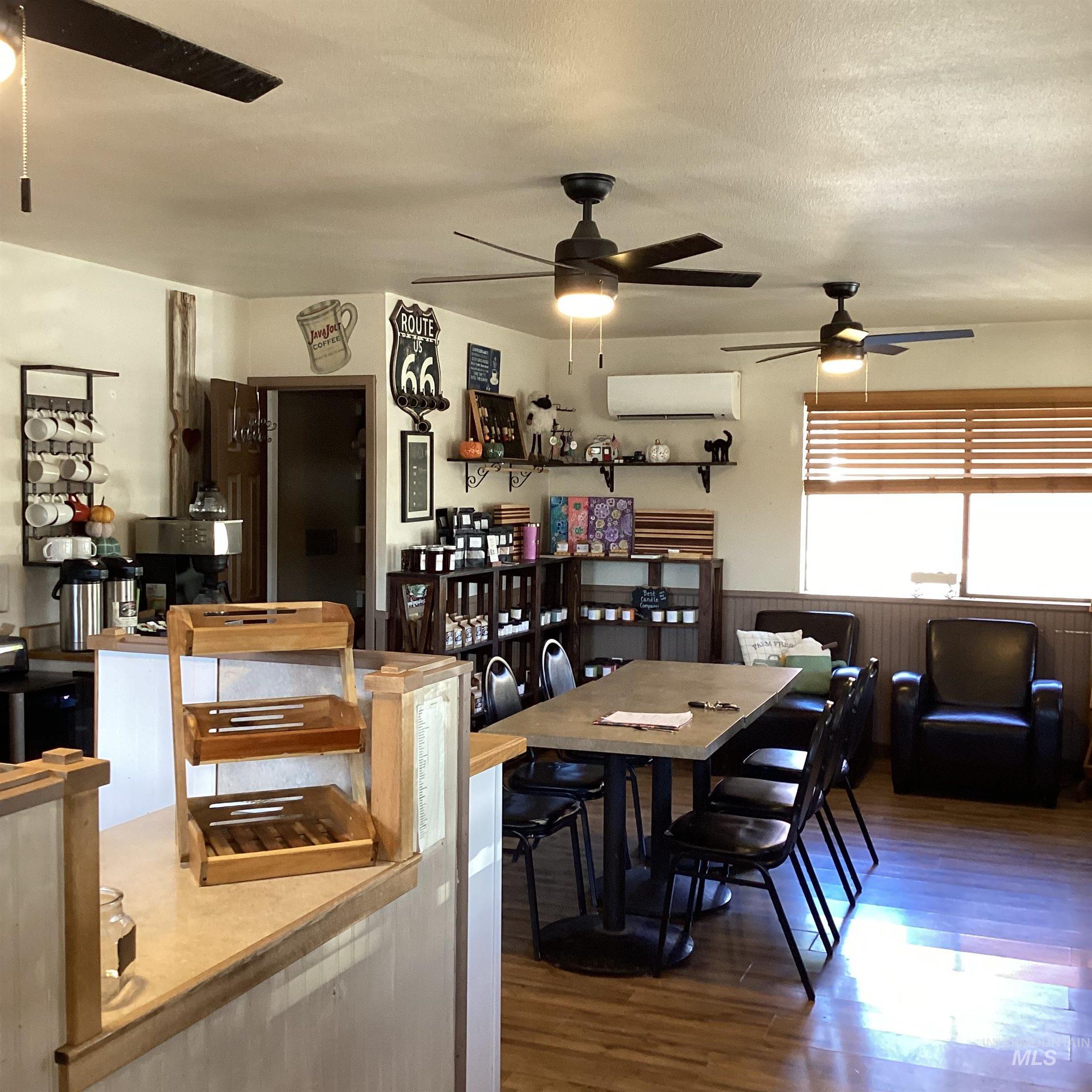Dining area with dark wood-style floors, a wainscoted wall, ceiling fan, a textured ceiling, and a wall mounted AC