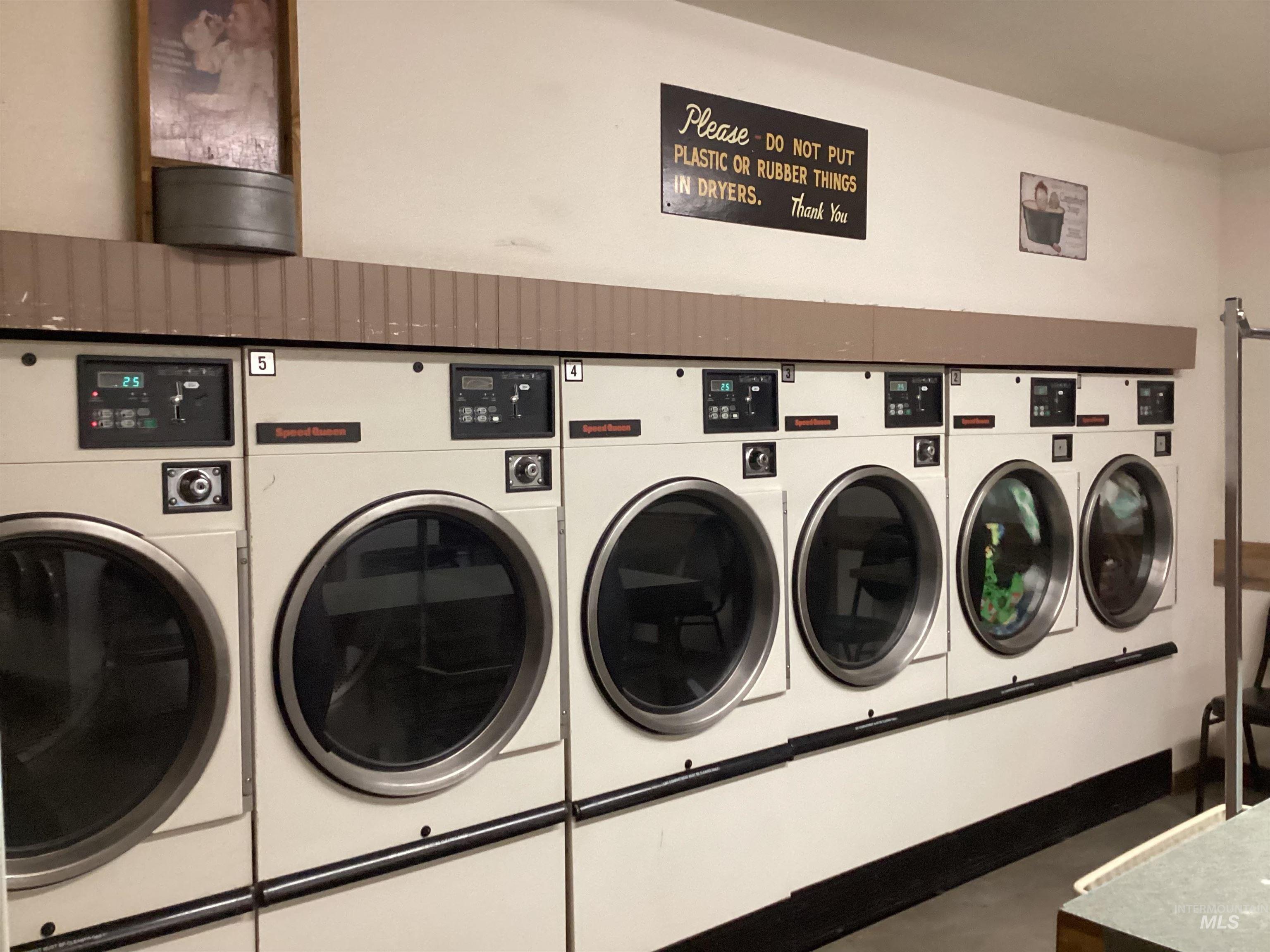 Community laundry room featuring washing machine and clothes dryer