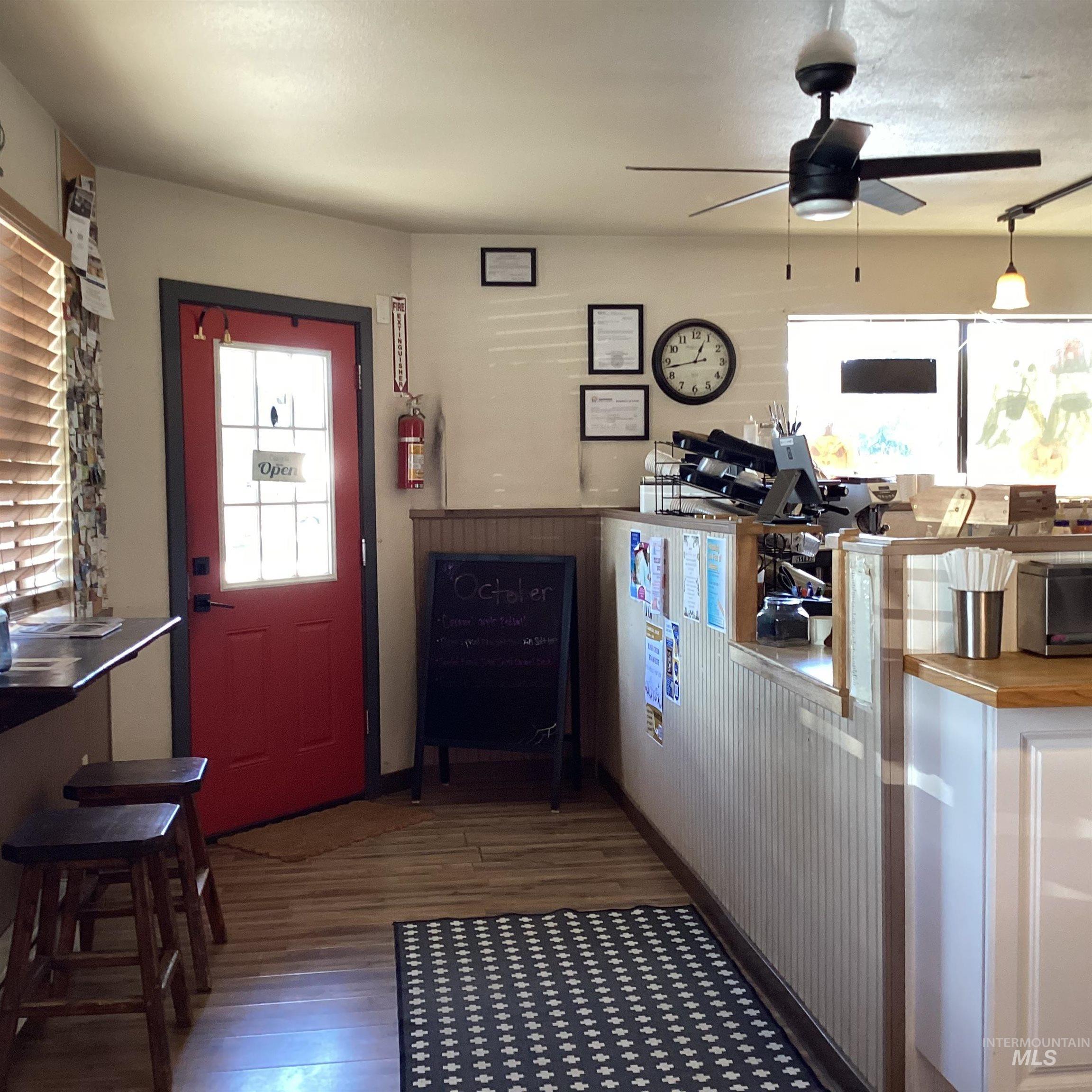 Foyer entrance with healthy amount of natural light, dark wood finished floors, and ceiling fan