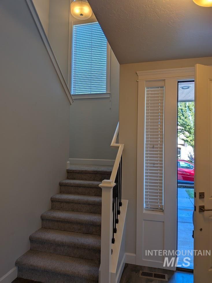 Stairs with a textured ceiling and baseboards