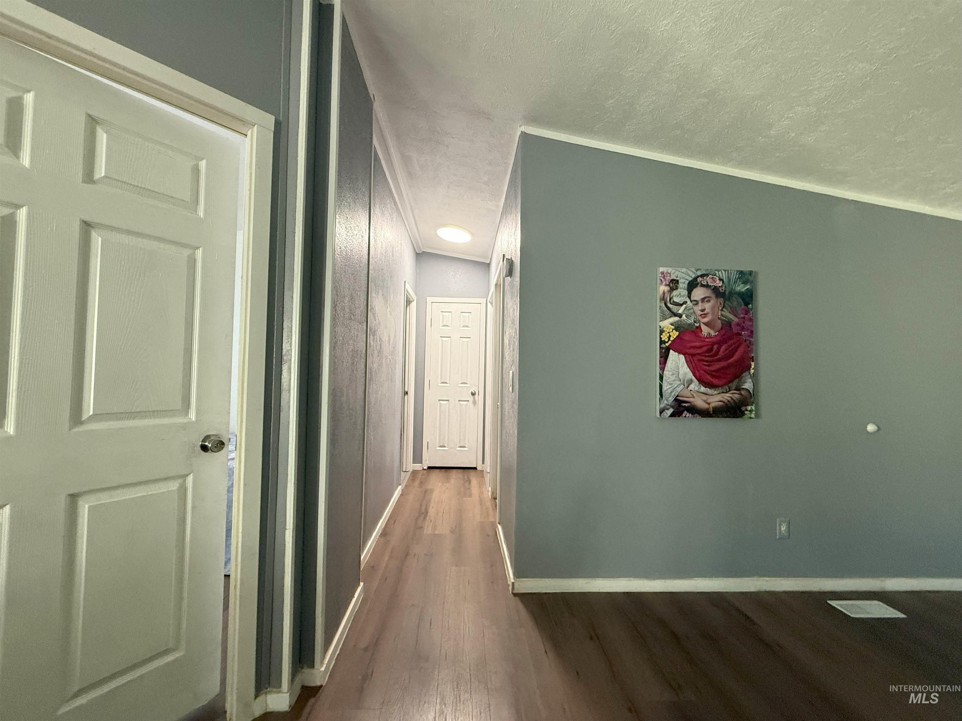 Hall featuring dark wood-style floors and a textured ceiling