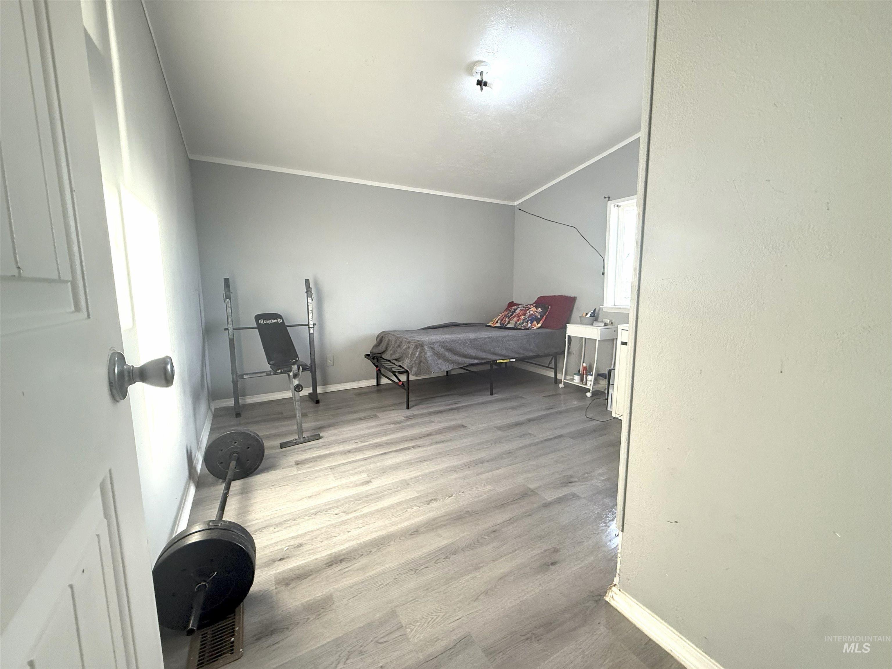 Bedroom with light wood-style floors and ornamental molding