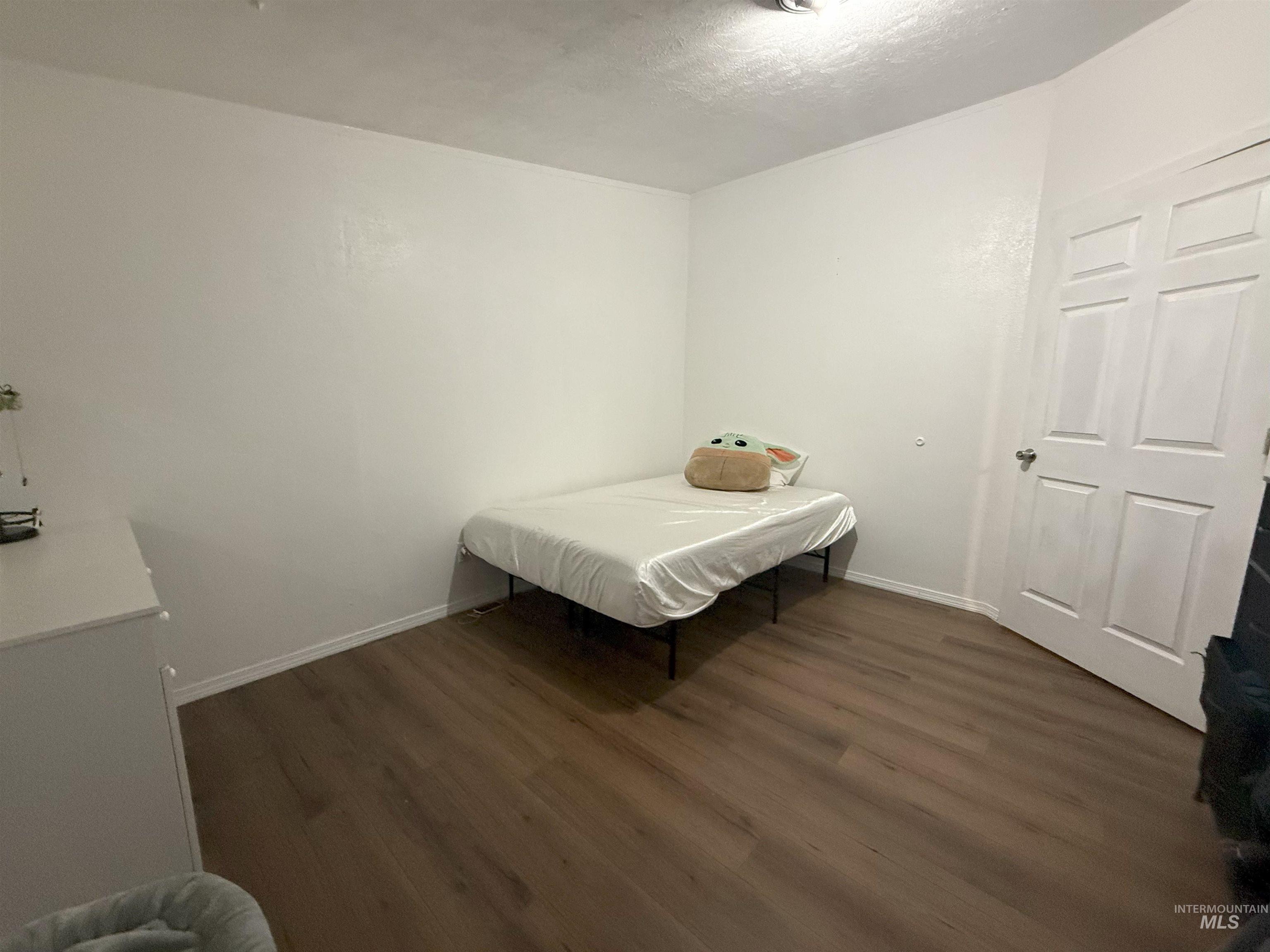 Bedroom featuring dark wood-style floors and a textured ceiling
