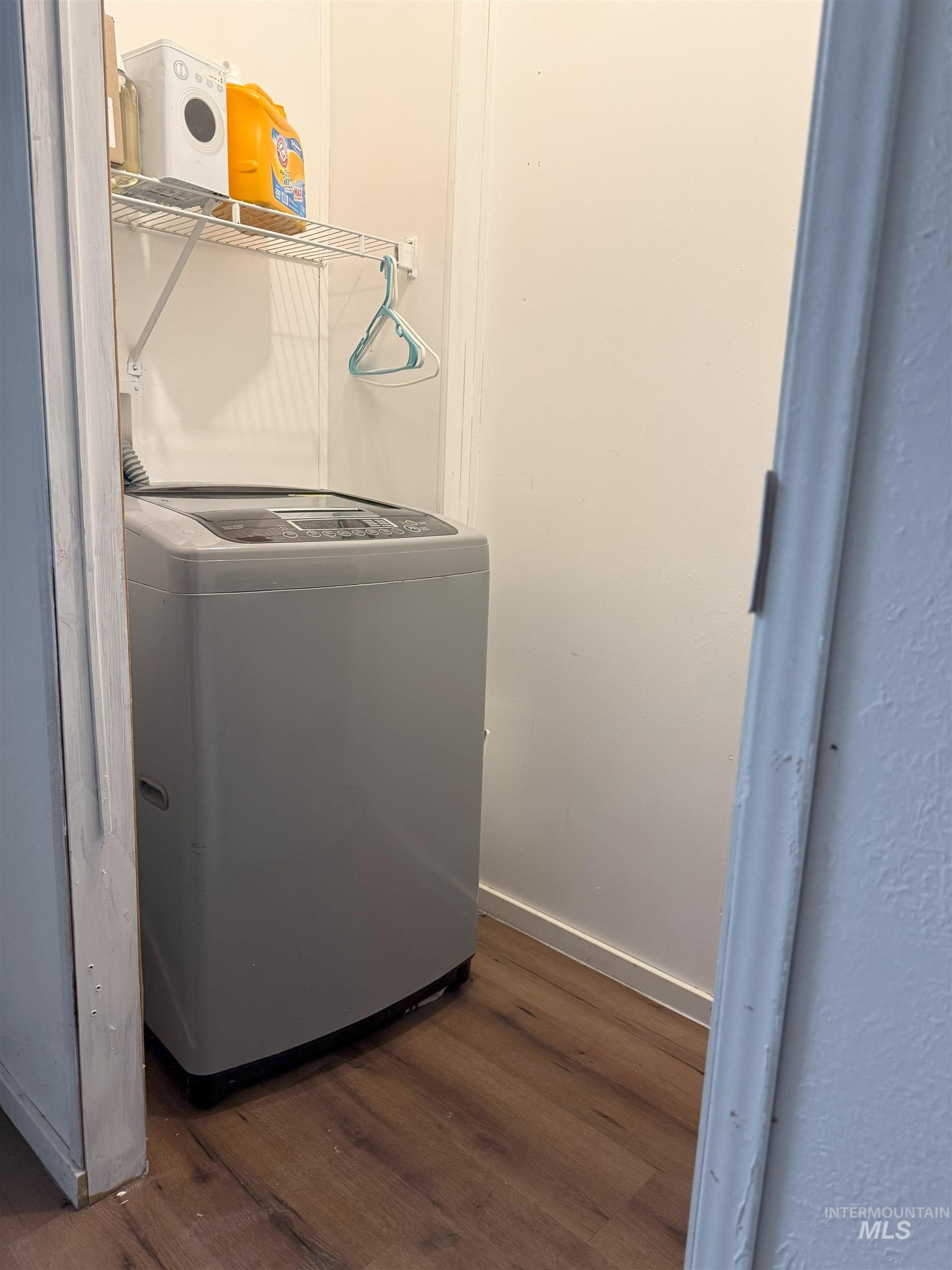 Washroom with dark wood-style flooring and washer / clothes dryer