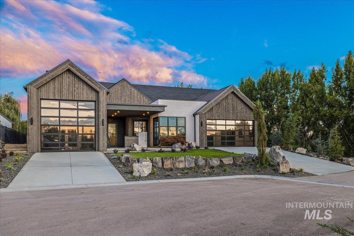 View of front of property with concrete driveway and an attached garage