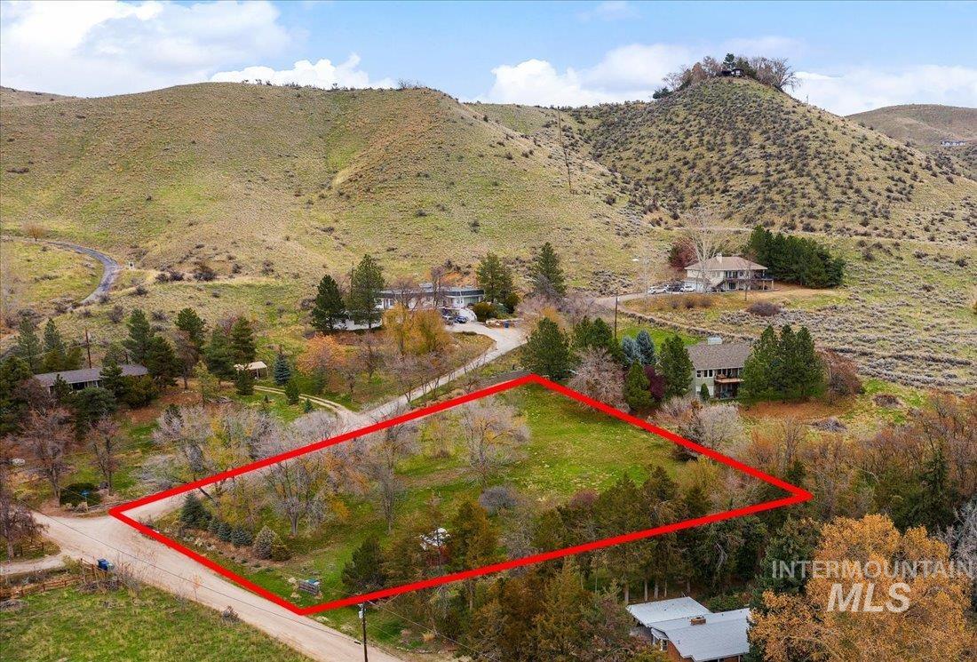 Aerial view of property and surrounding area featuring property parcel outlined and mountains