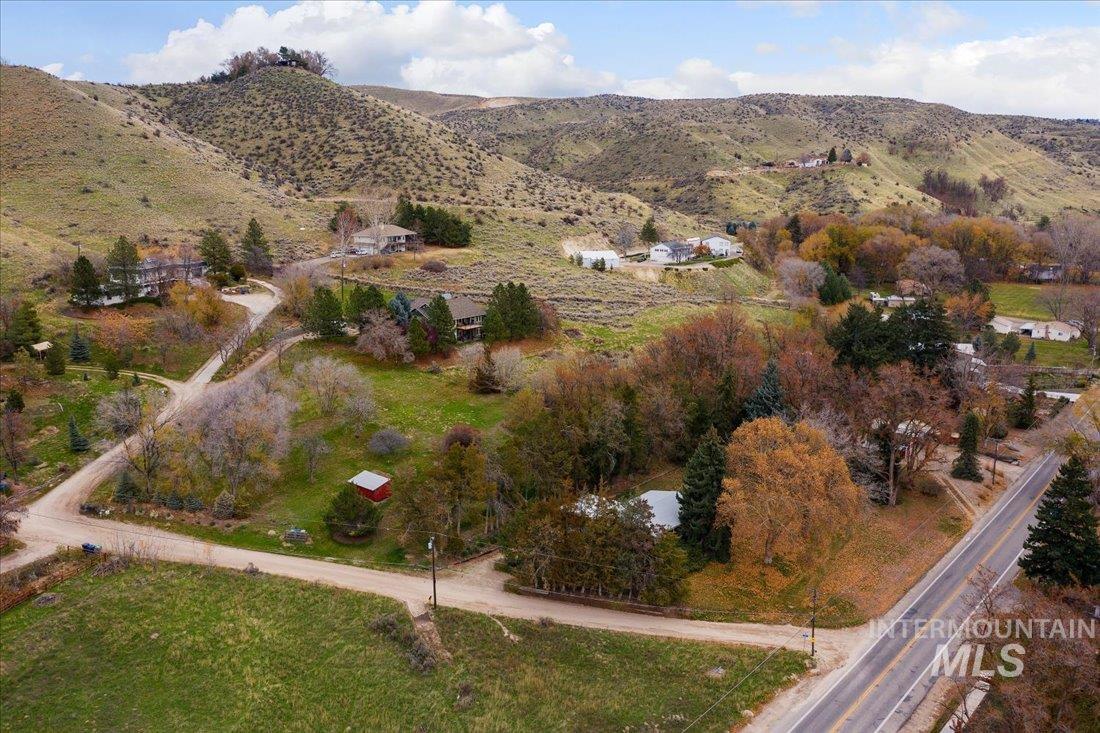 Aerial view of property and surrounding area featuring a mountainous background