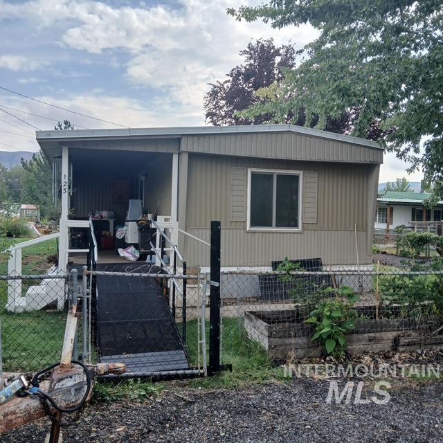 View of side of home with a fenced front yard and a gate