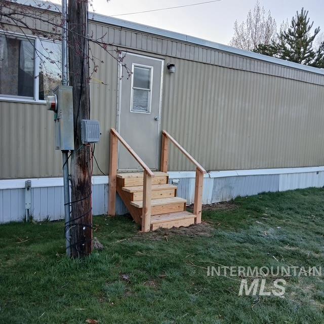Back of property with a yard and entry steps