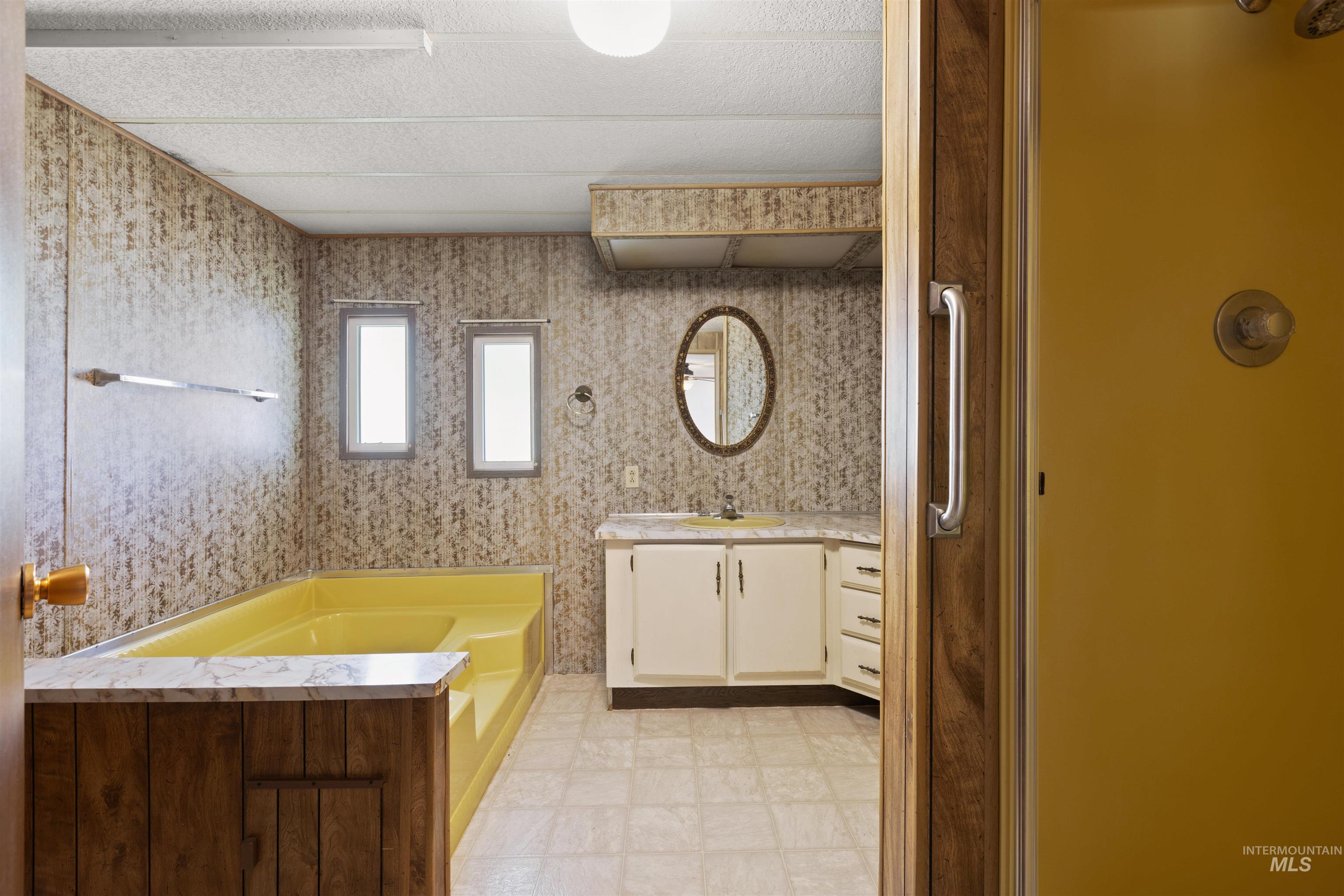 Full bathroom with a bath, vanity, and light flooring