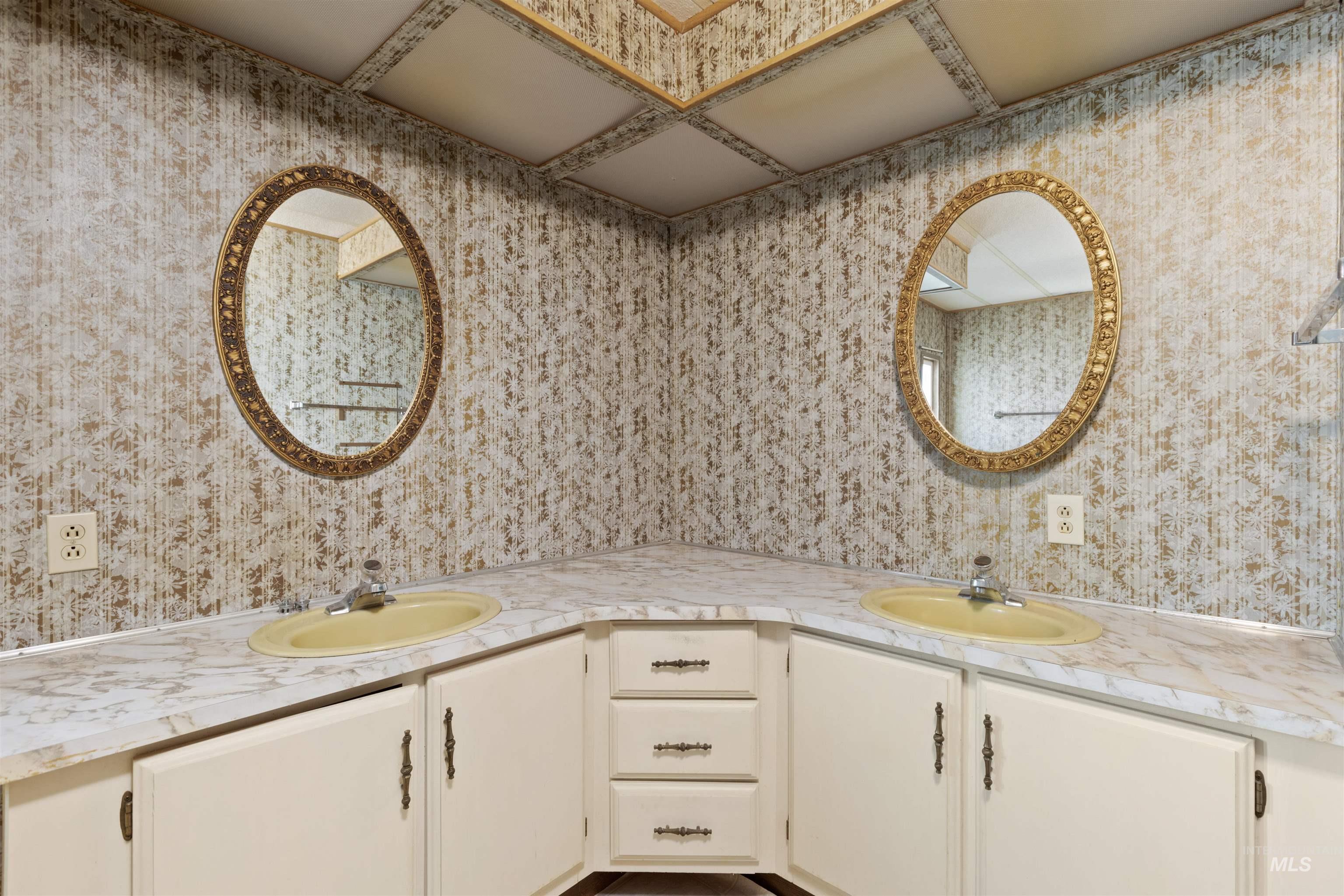 Full bath featuring wallpapered walls and double vanity