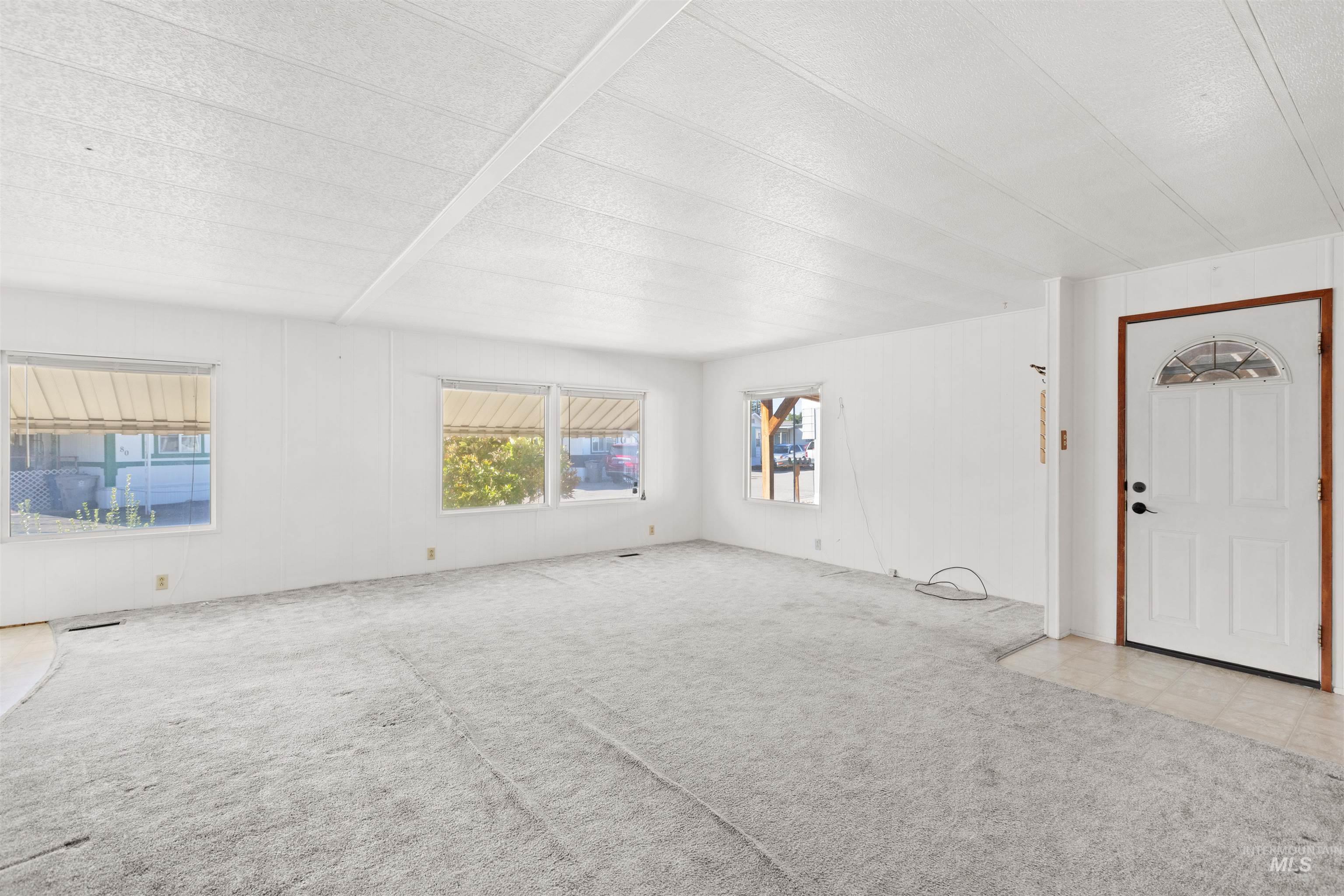 Unfurnished living room featuring carpet and a textured ceiling
