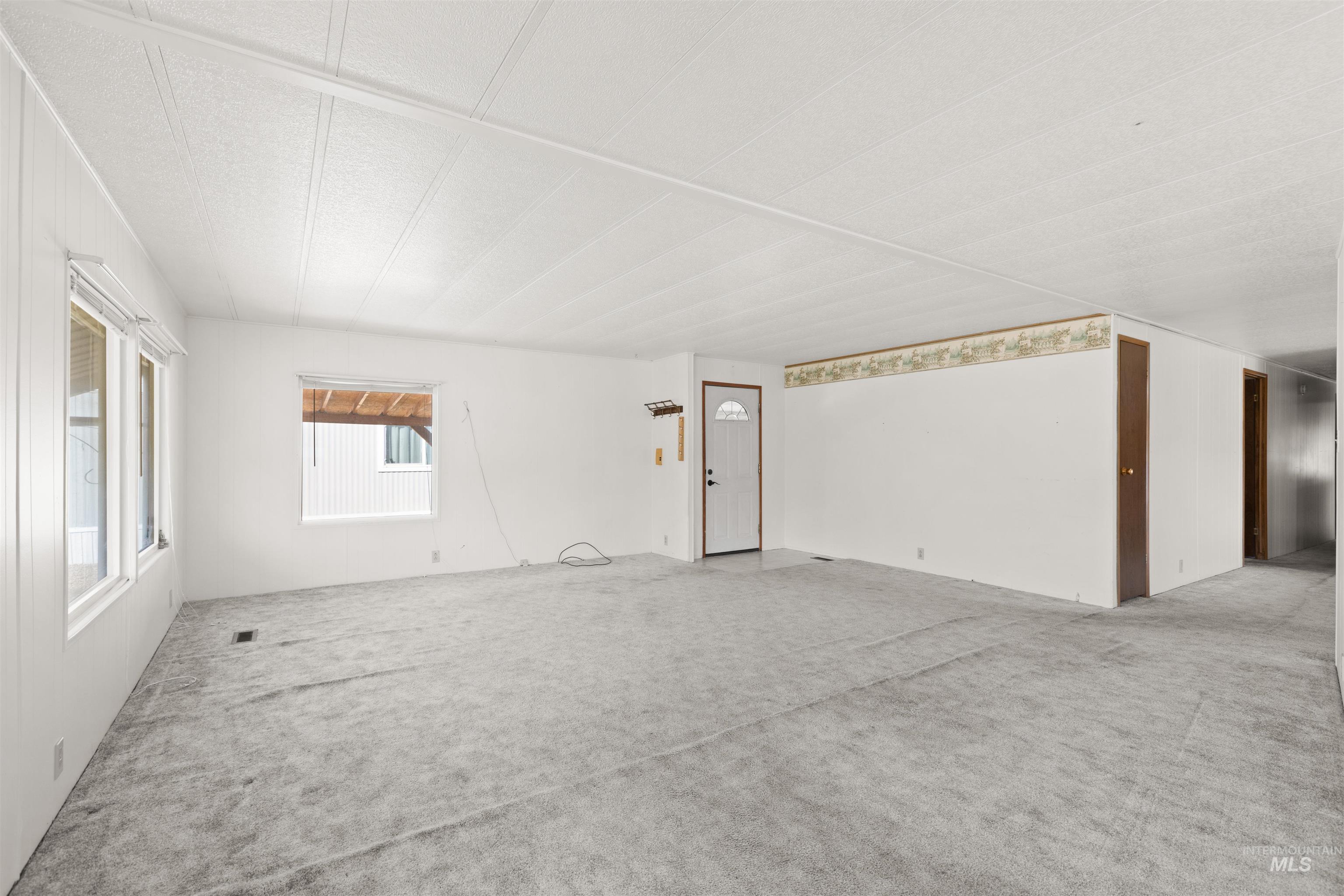 Unfurnished living room featuring carpet