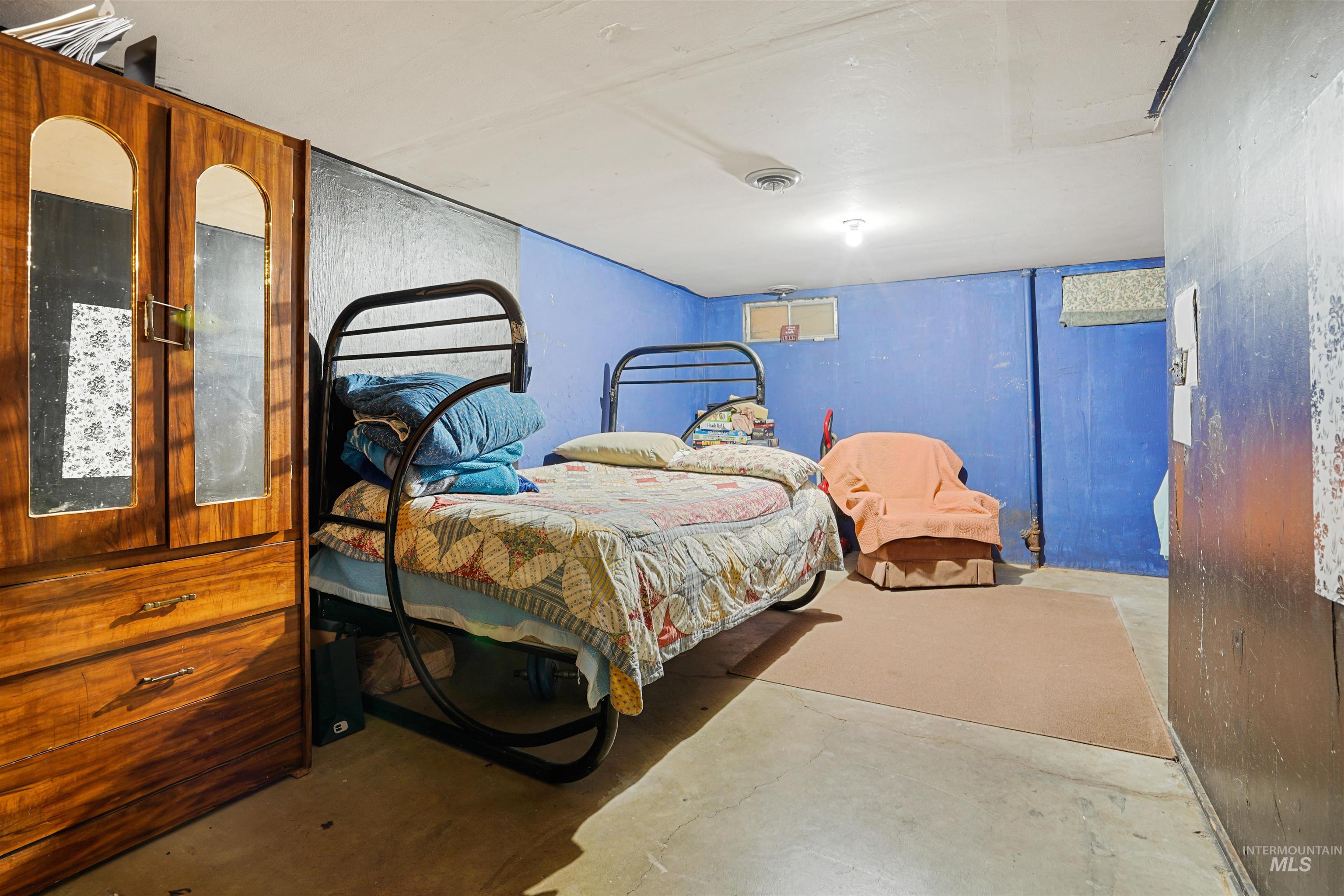 Bedroom with unfinished concrete floors