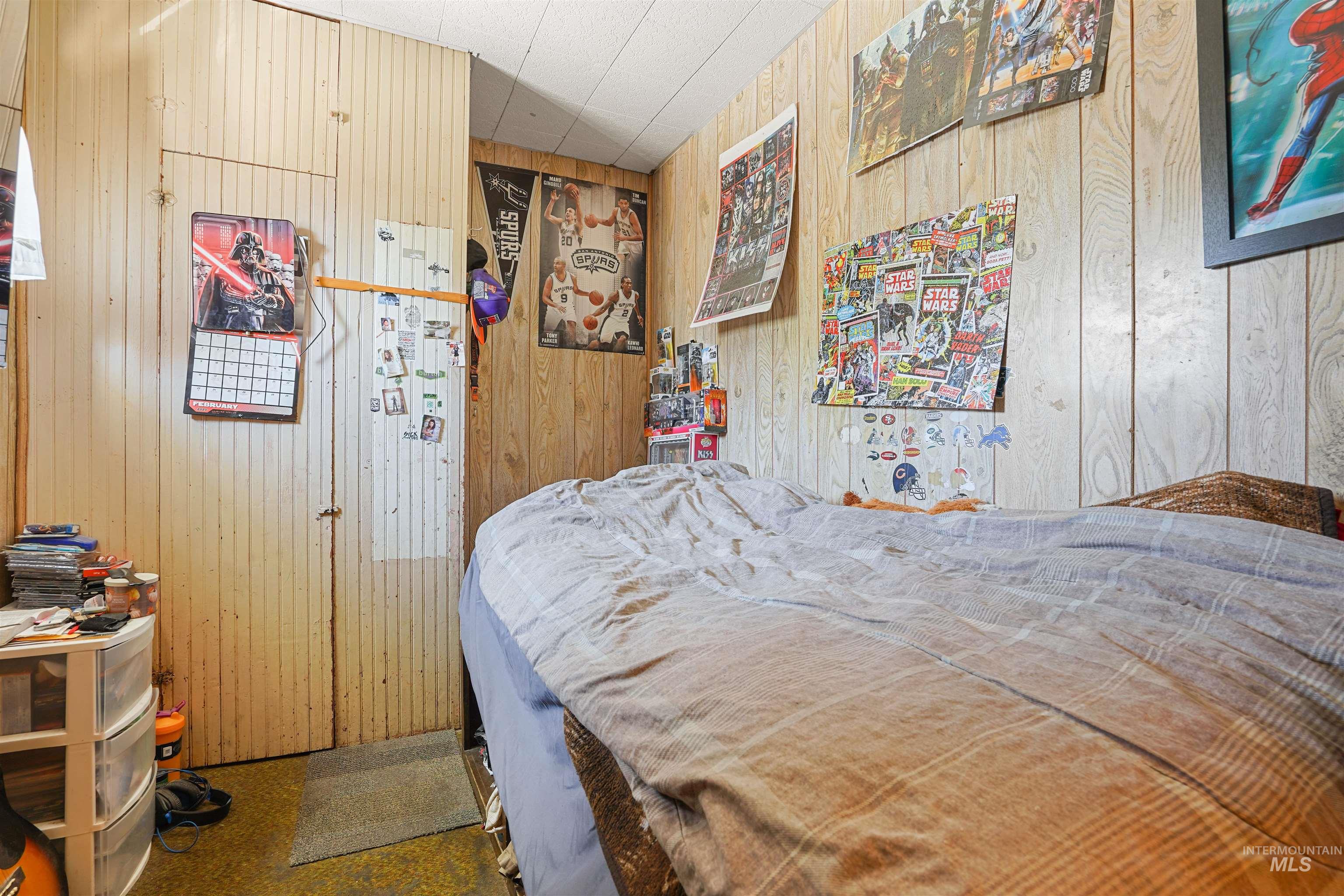 Bedroom featuring wood walls