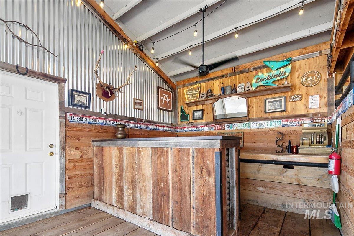 Bar featuring wood walls and wood-type flooring