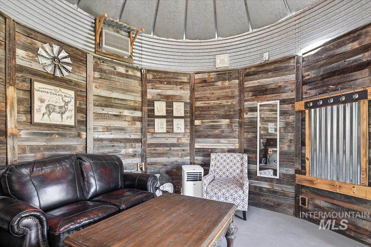 Sitting room featuring wooden walls and concrete floors