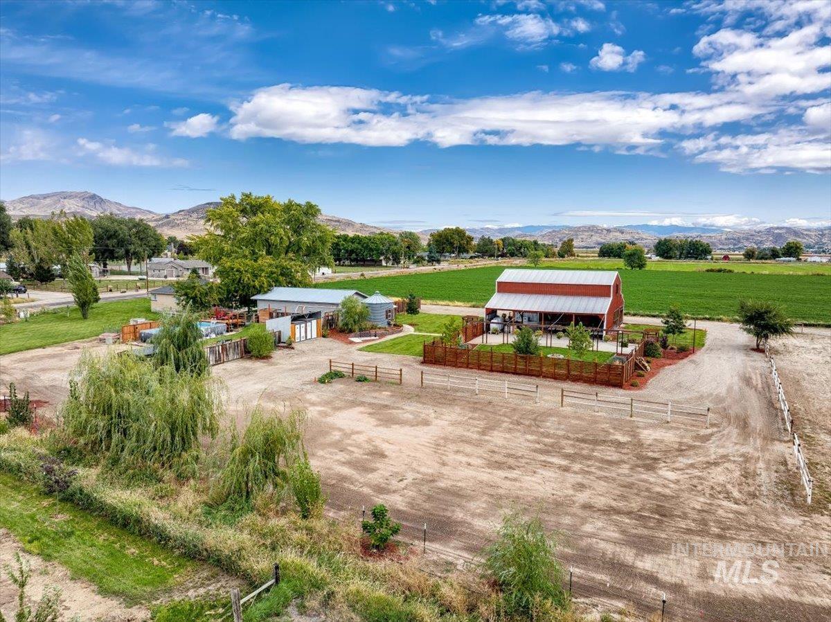 Surrounding community featuring an outdoor structure, an outbuilding, a mountain view, and a patio