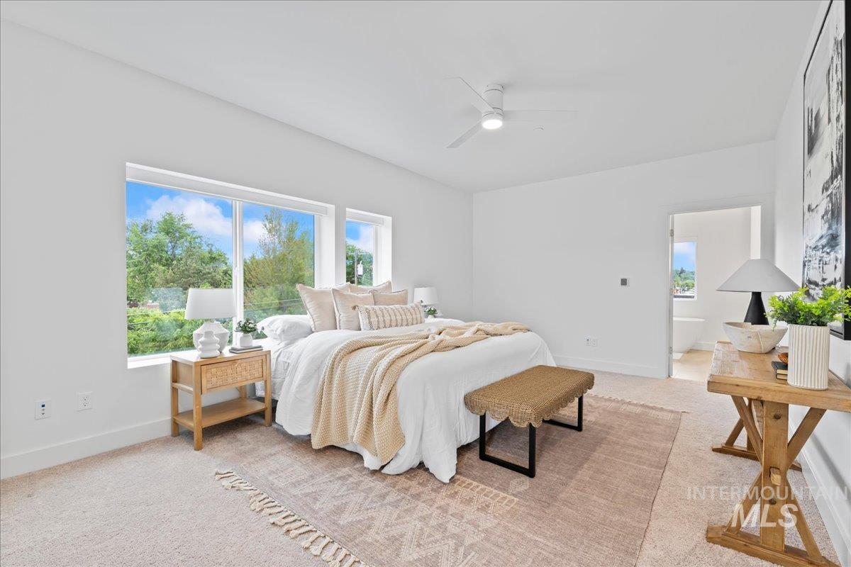 Bedroom featuring light carpet, connected bathroom, and ceiling fan