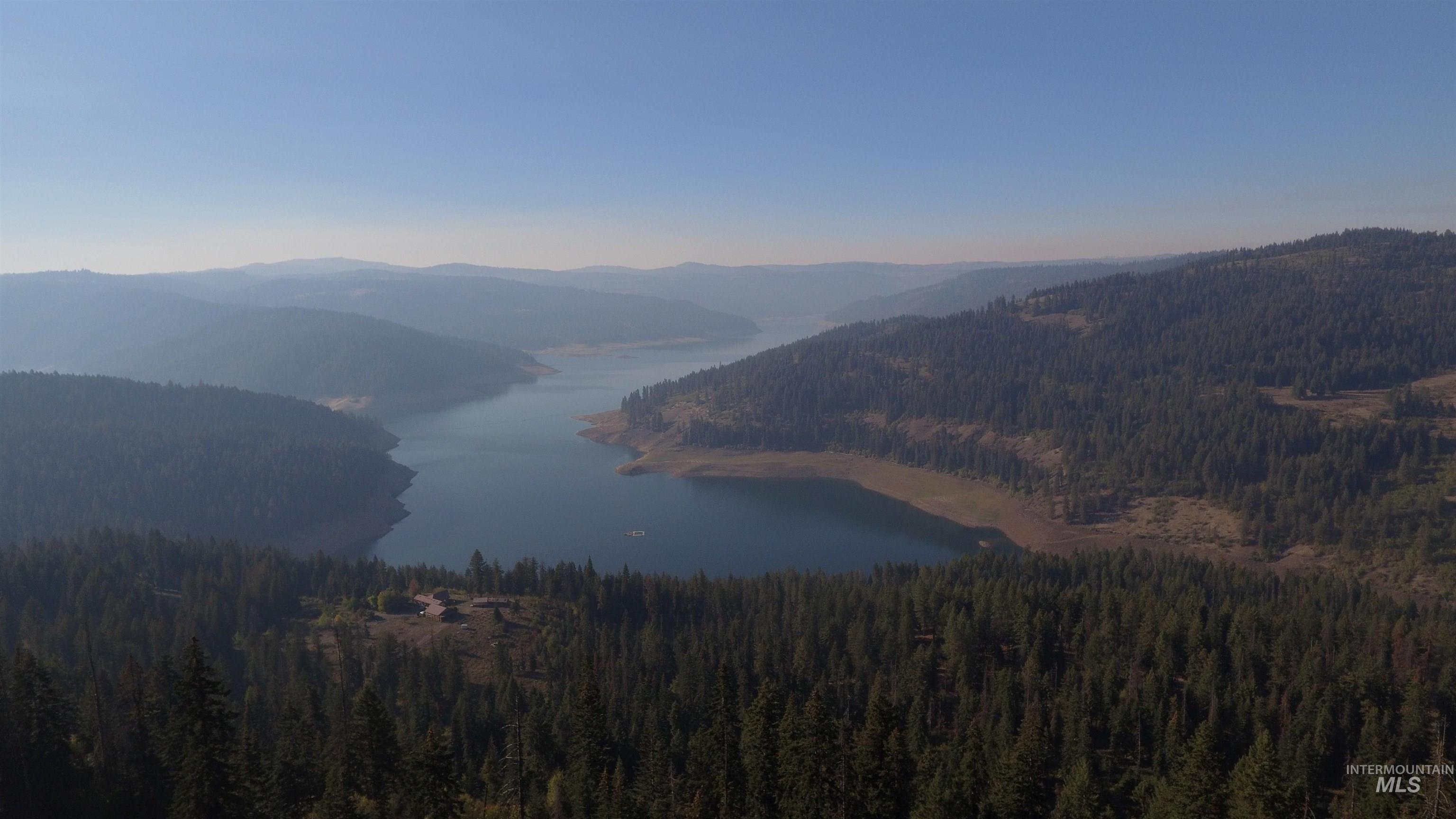 View of mountain backdrop with a large body of water and a heavily wooded area