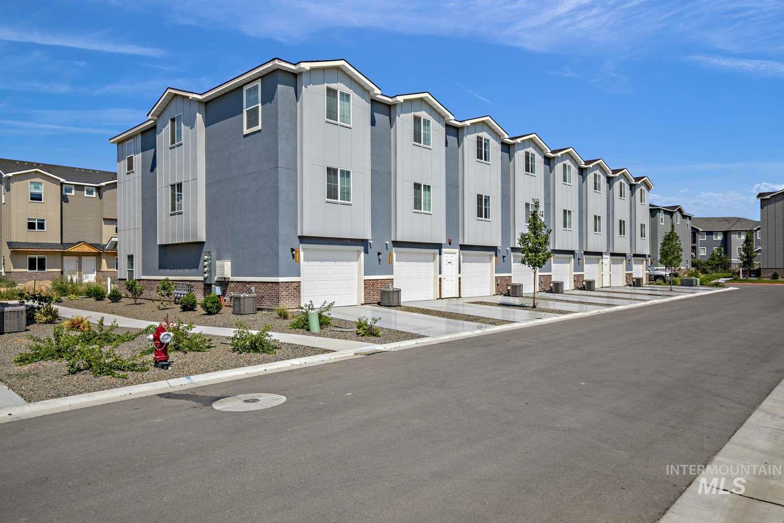 View of property with a residential view and an attached garage
