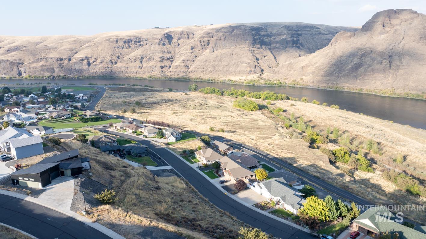Aerial view of property and surrounding area with nearby suburban area and a nearby body of water